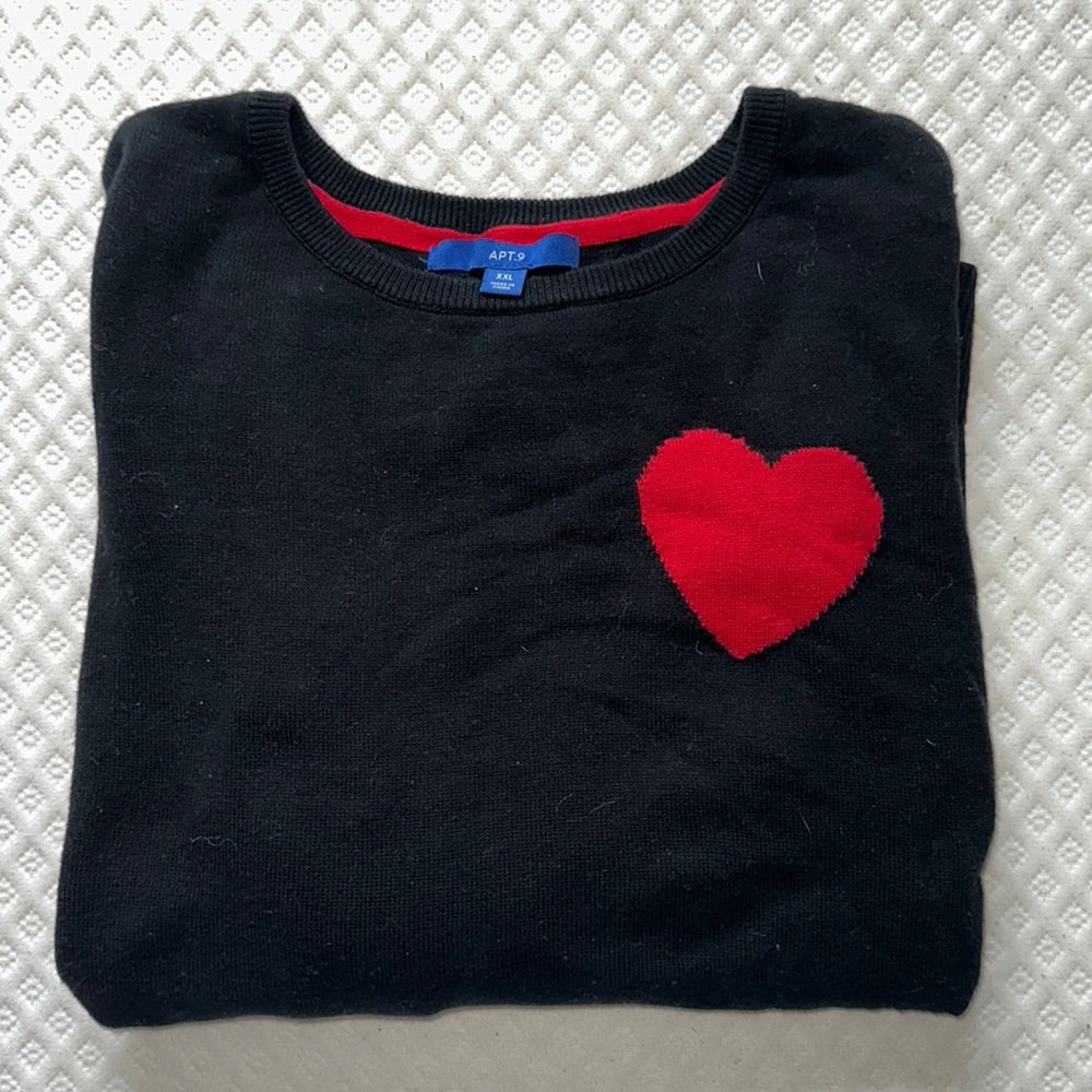 Black sweater with red heart on the side and red trim on sleeves